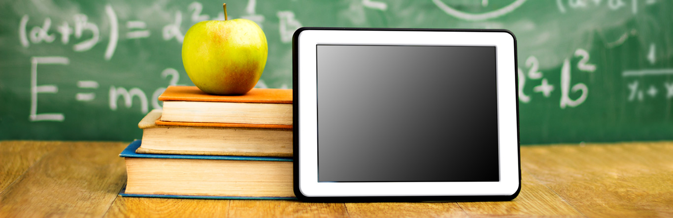 education main image Green apple on 3 books next to a tablet in front of a chalk board