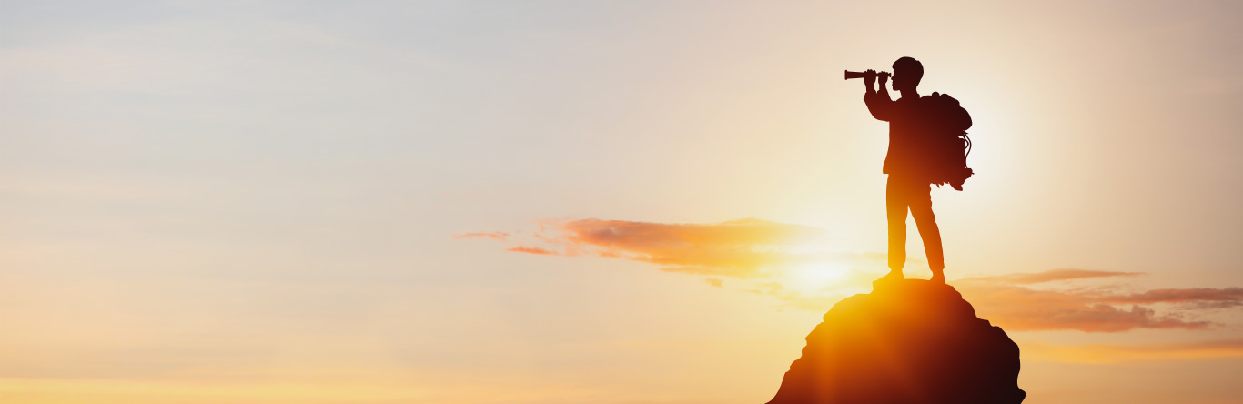 Man on a mountaintop looking through a telescope