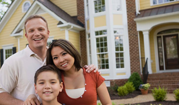 Family smiling outside home